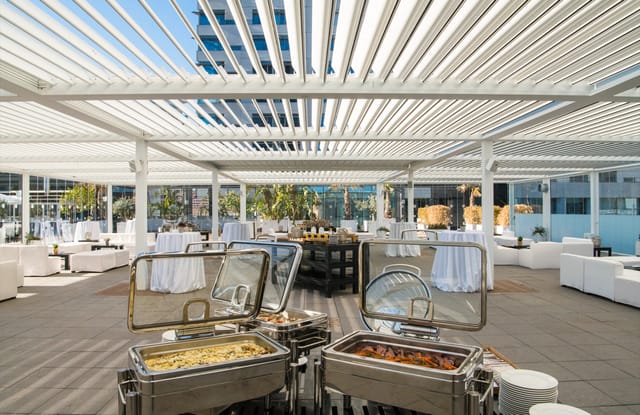 Rooftop Glasshouse at Purobeach Barcelona: corporate networking event with pergola lounge seating.