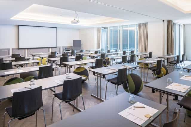 Modern classroom-style conference room at Hotel MAXX Vienna with ergonomic seating for meetings.