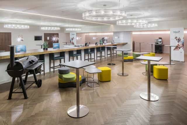Modern breakout room with high-top tables for corporate events and networking happy hours.