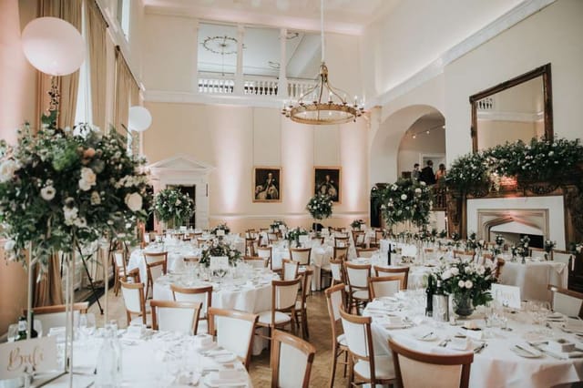 Farnham Castle Great Hall ballroom with elegant floral tablescapes for wedding reception events.