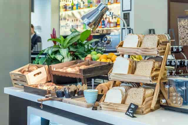 Continental breakfast station with wooden risers at an Accor meeting room event venue.