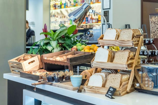Continental breakfast station with wooden risers at an Accor meeting room event venue.