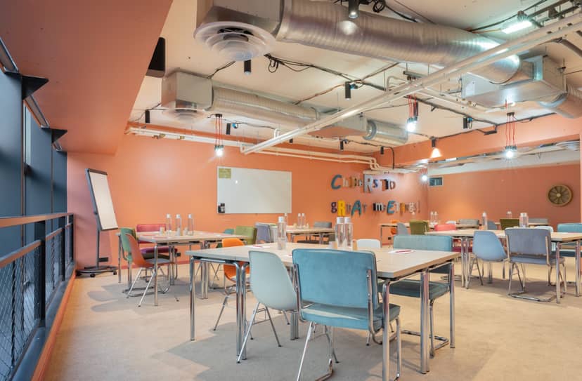 Modern breakout room with industrial ceiling for collaborative meetings and workshop events.