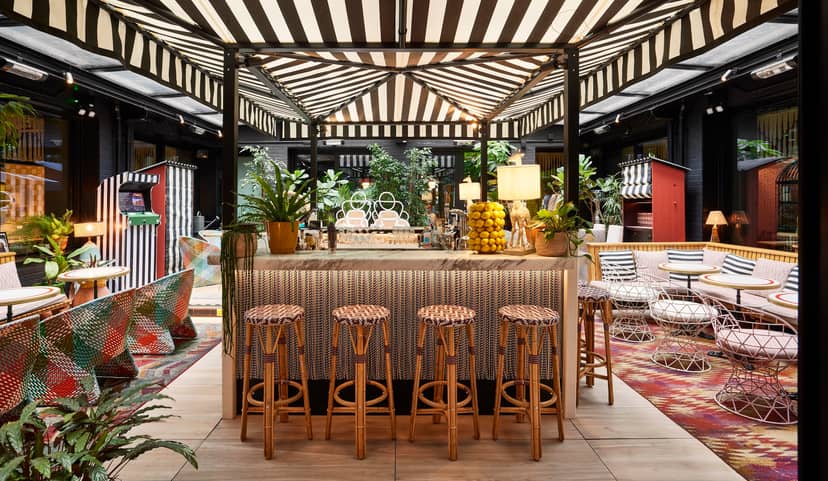 Stylish Garden Bar at Mama Shelter London with striped canopy, perfect for events and gatherings.