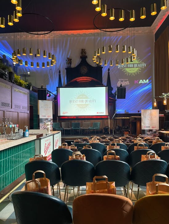 Full Venue at Amazing Grace with green chairs for a "Quest for Quality" event.