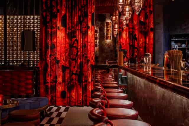 Vibrant bar at Chateau Denmark, featuring rich red decor for elegant networking events.
