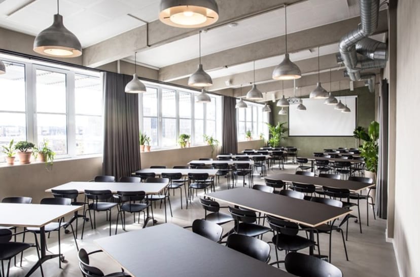 Industrial-chic meeting room in SOHO Copenhagen with classroom seating for corporate workshops.