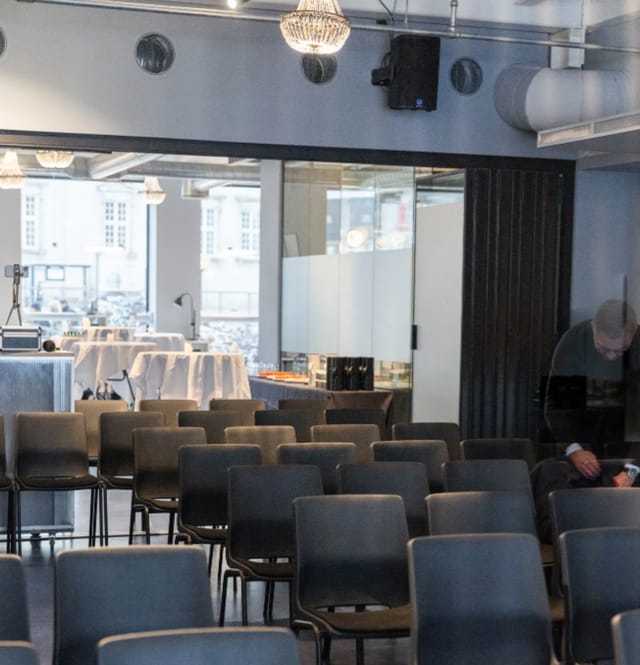 Hybrid event setup at Mesh Matrikel1 with theater seating and networking cocktail tables.