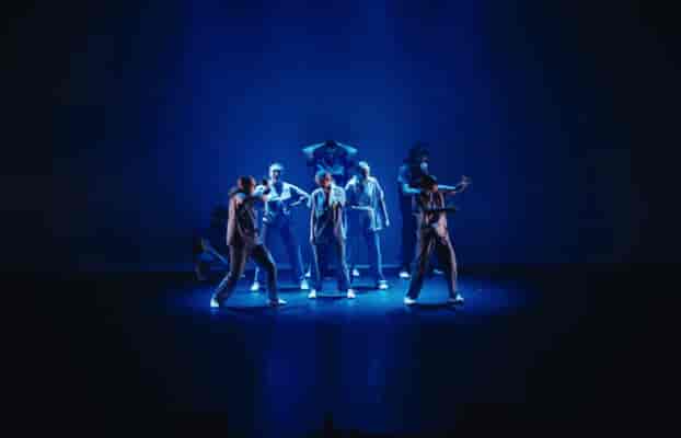 Performers in moody blue lighting at an MPAA Academy dance studio stage production.