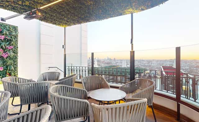 Chic outdoor VIP event space at Hotel Riu Plaza España with panoramic sunset views.