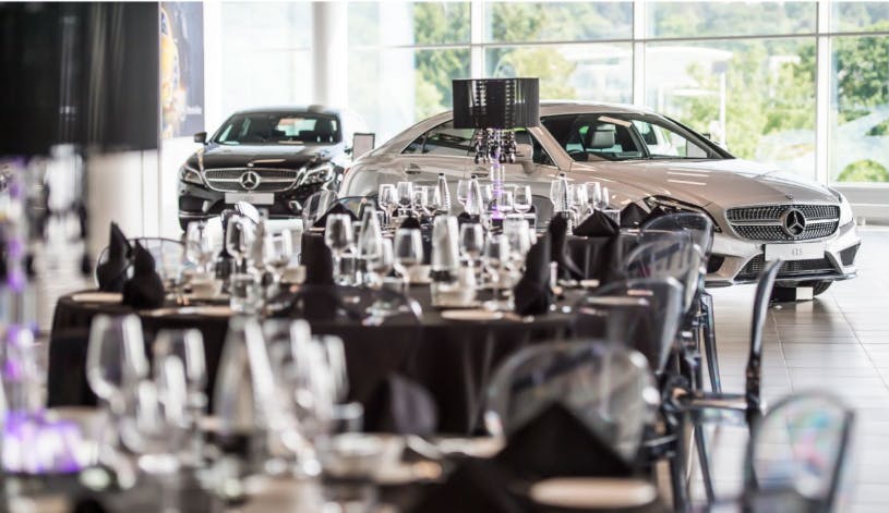 Elegant event setup at Mercedes-Benz World with luxury cars, ideal for corporate events.