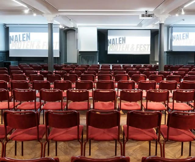 Conference setup in Stora Salen, featuring red chairs for engaging presentations.