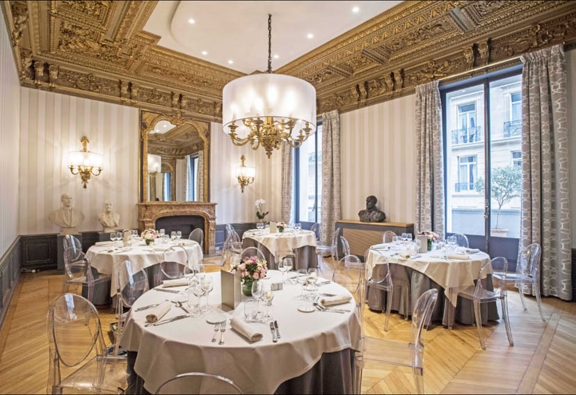 Neoclassical meeting room with modern Ghost chairs for executive luncheons and board dinners.