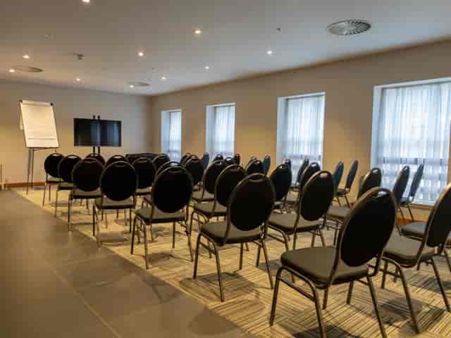 Meeting room at The Baird, featuring black chairs for workshops and presentations.