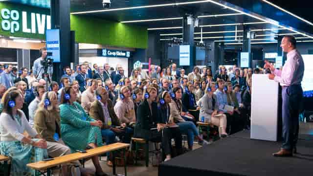 "Vertu Place Co-op Live event with engaged audience in headphones for silent conference"