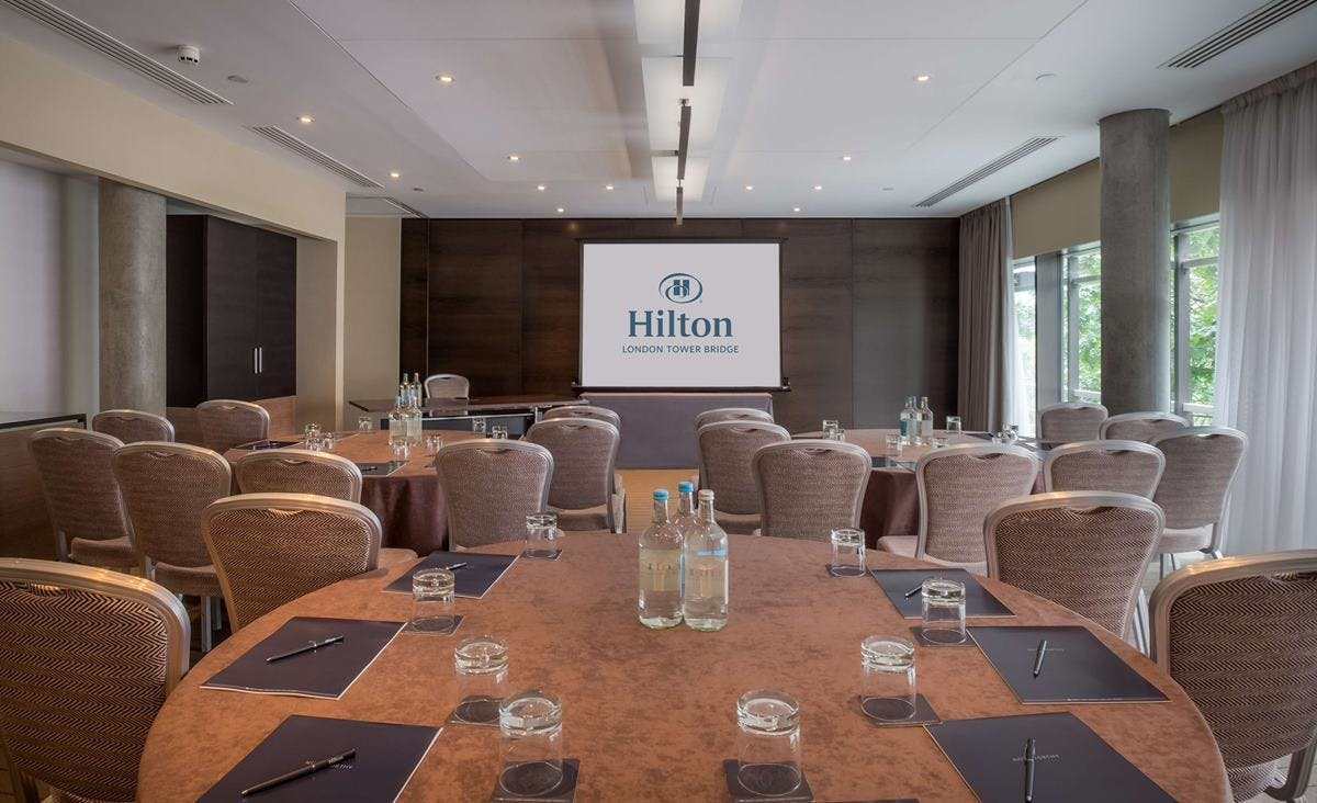 Event space at Hilton London Tower Bridge with round tables for corporate meetings.