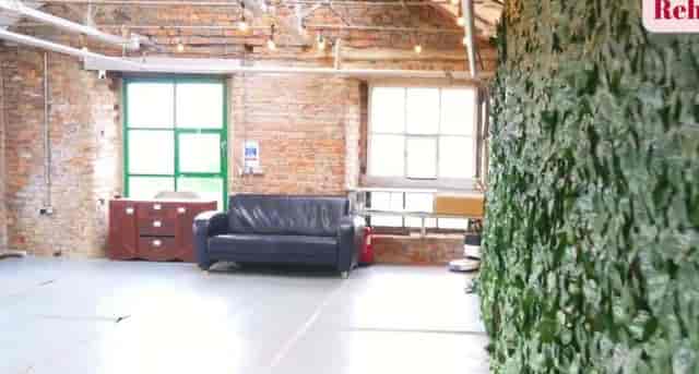 Industrial-chic rehearsal studio with brick wall, perfect for networking events and workshops.