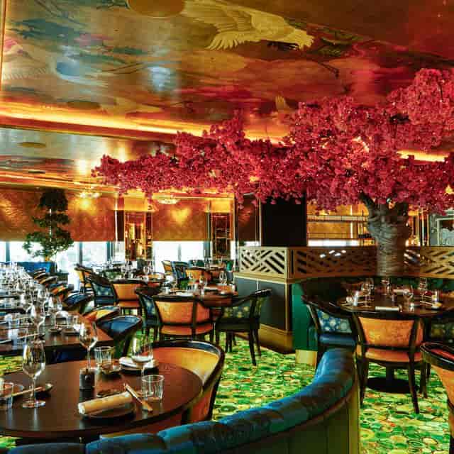 Sculptural red floral tree in Ōmí Lounge for corporate reception and brand activation.