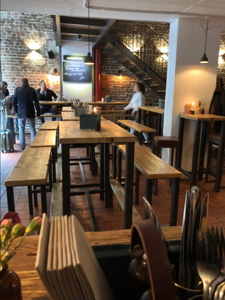 Industrial-chic dinner space with bench seating for corporate networking and events.