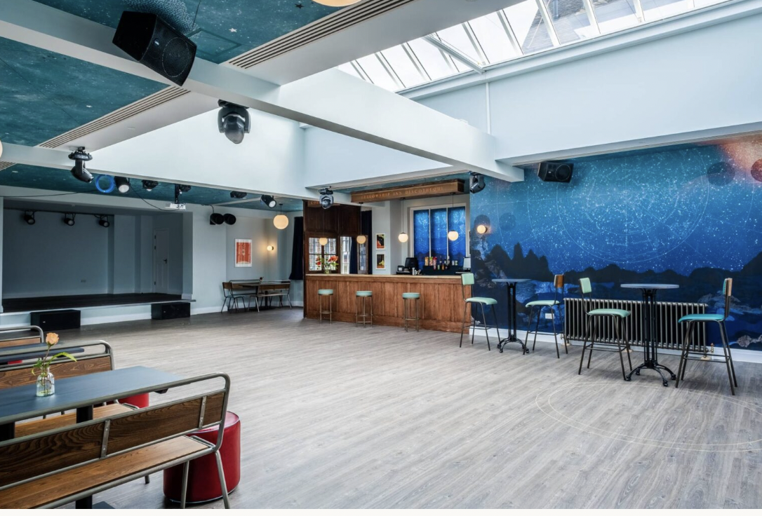 The Space event venue with stage and bar for receptions and networking.