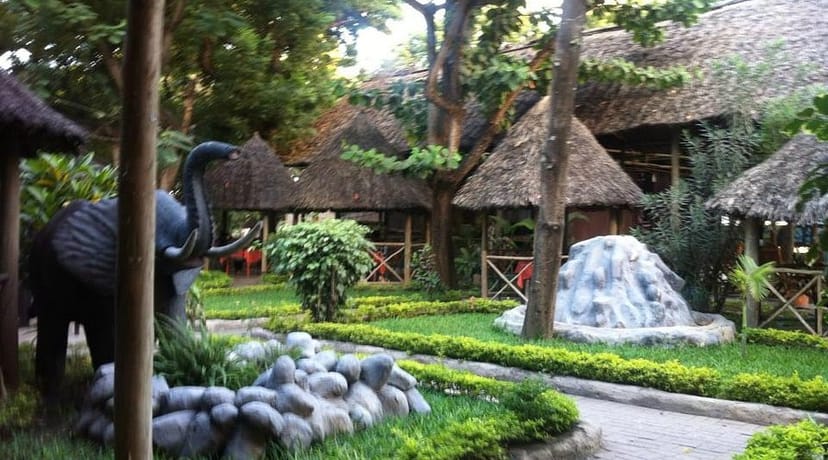 Thatched-roof gazebos at Makumbusho ya Taifa Botanical Garden for cultural team-building events.