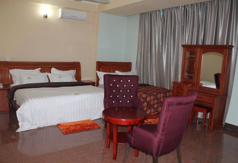 Wanyama Hotel room in Kariakoo with dated furniture, perfect for budget travel or event lodging.