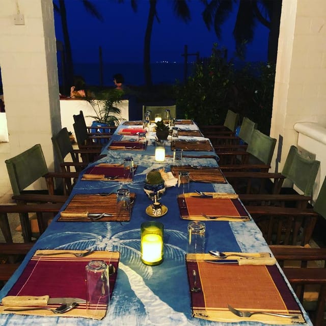 Upepo Garden al fresco private dinner, rustic wooden chairs, outdoor event, romantic dining venue.