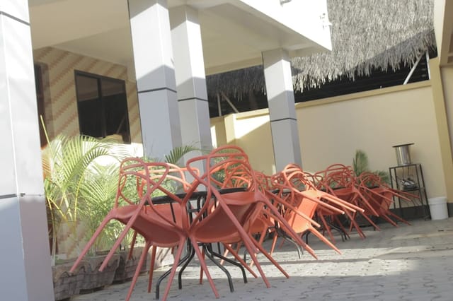 Outdoor lounge bar at Mambosasa View Hotel, Sinza: event setup area with stacked chairs.