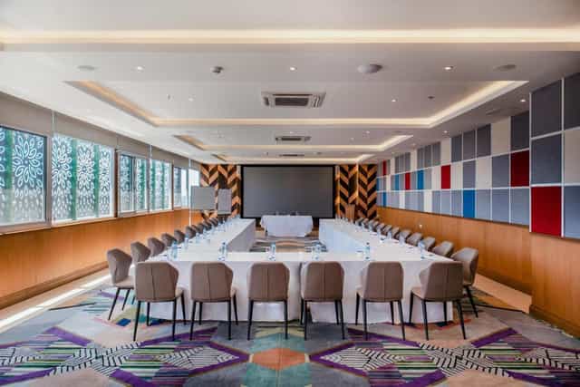 Aura Suites boardroom with U-shape setup and acoustic walls for professional workshops and events.