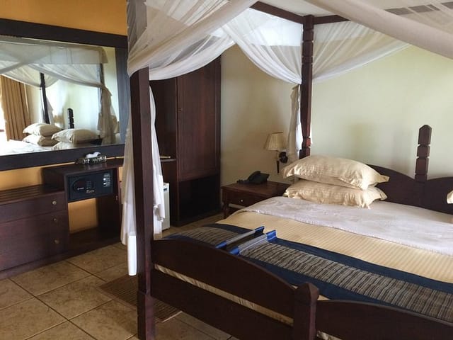 Four-poster canopy bed suite at Kigoma Hilltop Hotel for luxury incentive travel and VIP lodging.