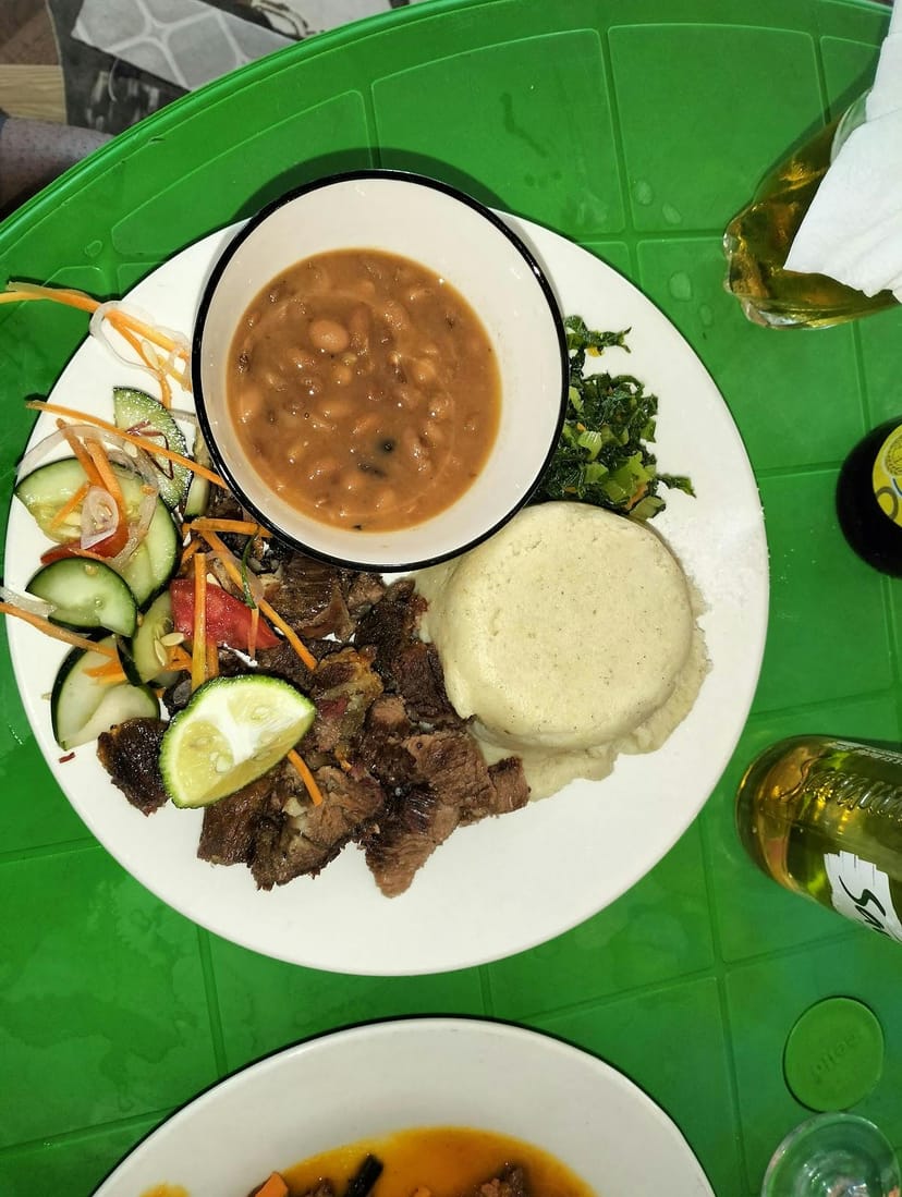 Rustic Mwika Hotel conference room set for casual networking lunch and cultural breakout session.