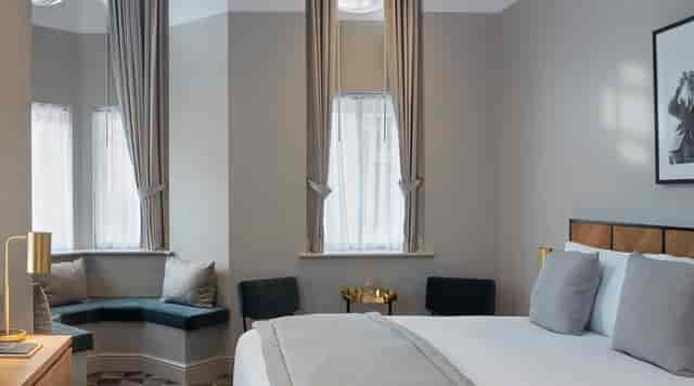 Victory House Hotel upscale suite with seating nook, ideal for executive meetings and event stays.