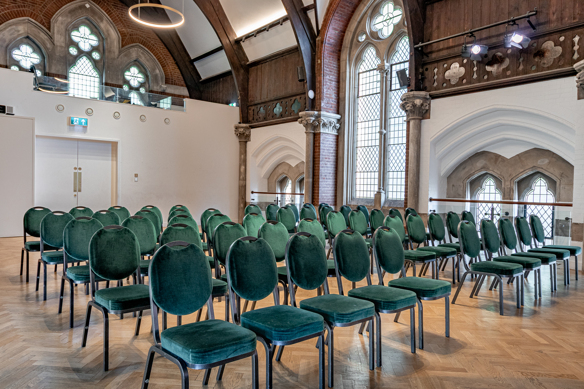 Upper Hall Gothic venue with green seating for boutique conferences and speaker sessions. - Banner