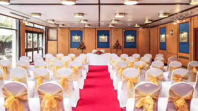 Wedding ceremony setup in Mercure Norwich function room with theater seating and gold sashes.