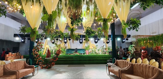 Emerald Hall stage with lush botanical decor for luxury gala and wedding event venue.