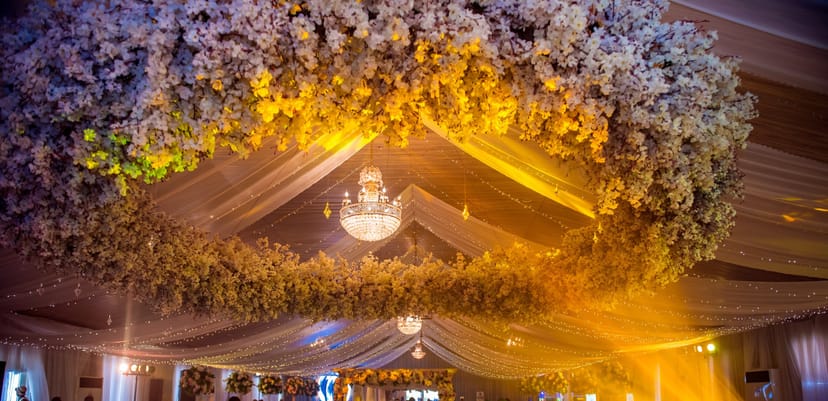 Emerald Hall floral ceiling installation with chandeliers for luxury wedding event venue.