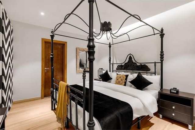 Four-poster bed in Villa Monument Hotel boutique suite, ideal for VIP speakers and retreats.