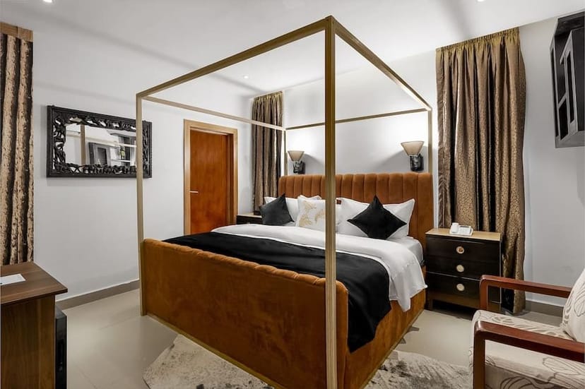 Gold canopy bed in Villa Monument Hotel boutique room, ideal for VIP speakers and incentive trips.