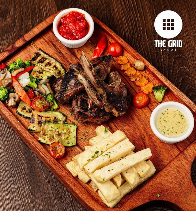 Seared lamb chops plated for a corporate gala, elegant rustic banquet dinner.