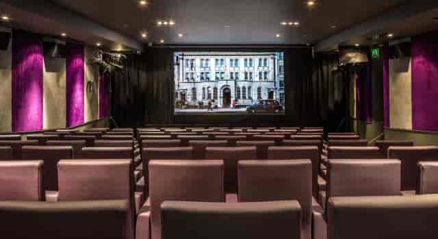 Cinema Room with plush tiered seating for corporate presentations and private film screenings.
