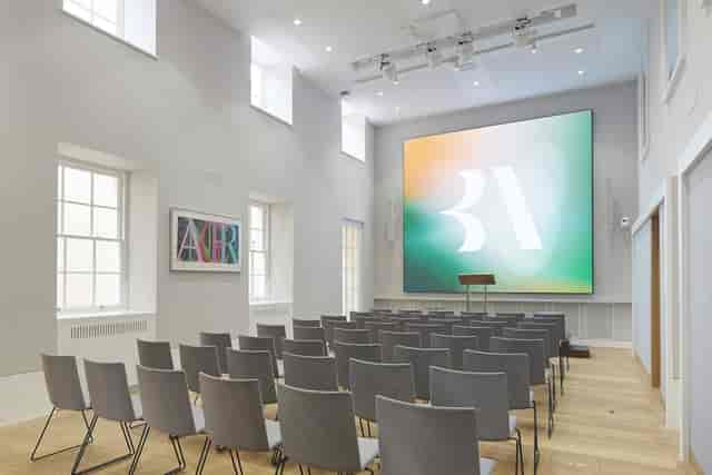 Theater-style corporate conference room with modern-heritage design for keynote presentations.