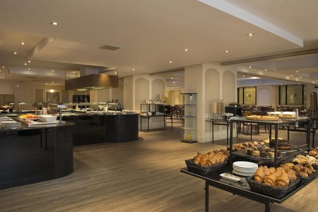 Spacious dining area in Meliá Milano, ideal for events and networking with buffet setup.