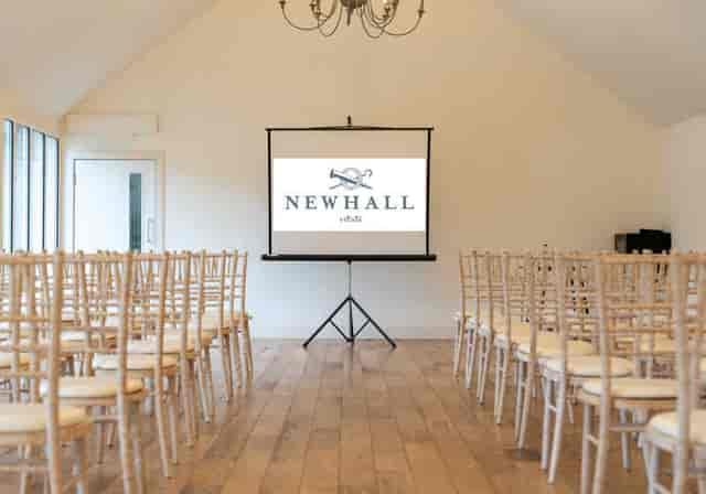 Newhall Estate Stable Room: theater-style corporate event space with wooden cross-back chairs.