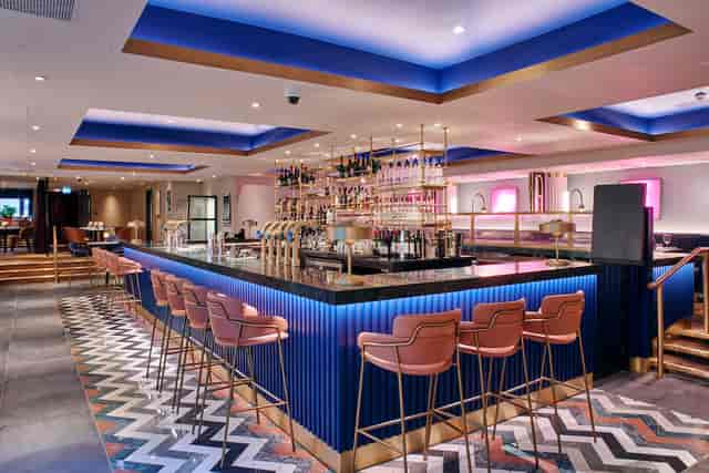 Blue-lit cocktail bar in Le Monde Hotel for corporate reception and networking event.