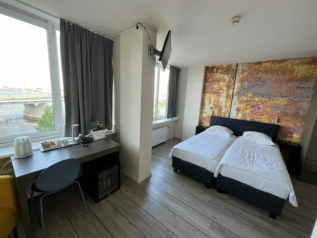 Thon Hotel Rotterdam twin guest room, industrial accent wall, budget business travel, event housing.