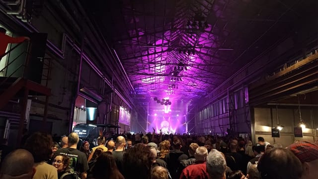 Industrial warehouse event venue with purple lighting for corporate events or galas.