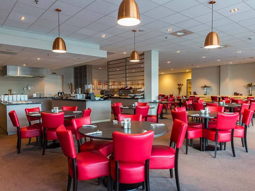 Rooftop banquet space in Rotterdam with red accents for networking events and corporate lunches.