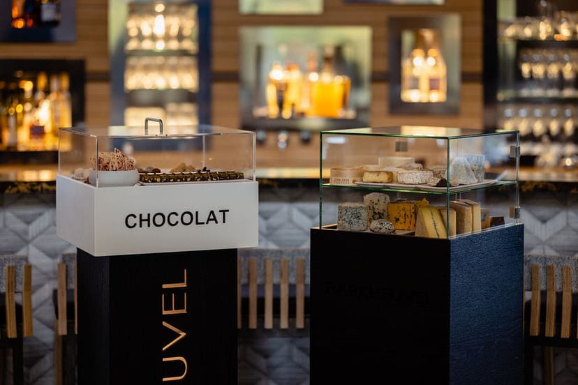 Elegant gala VIP lounge F&B station with curated chocolate and cheese displays.