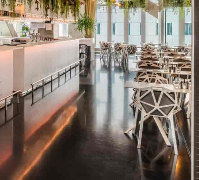 Modern event space in nhow Rotterdam, featuring a stylish bar and geometric chairs.