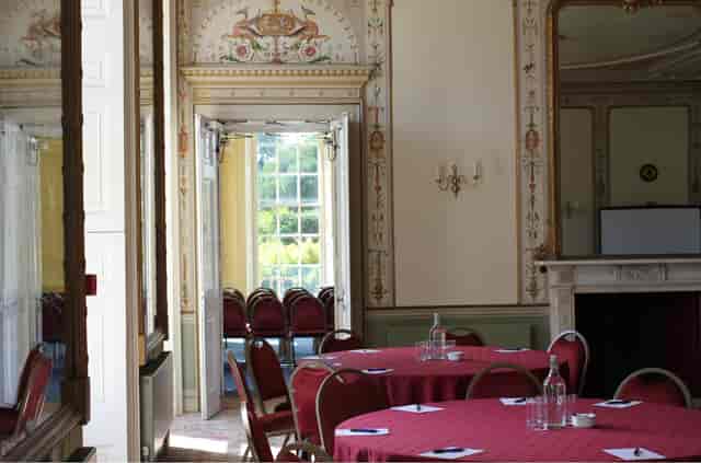 Banquet setup in historic Kingston Maurward room for corporate events and social gatherings.